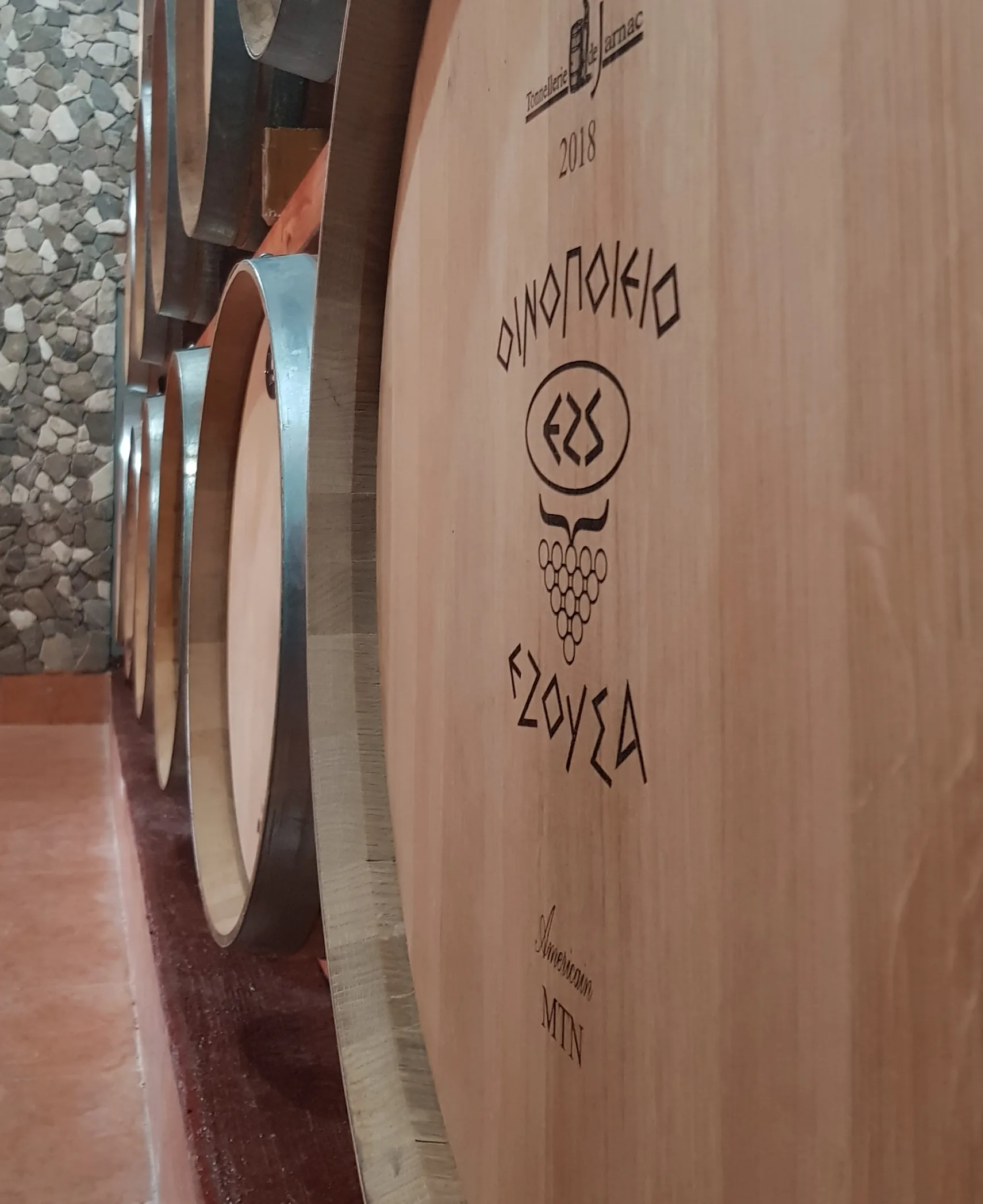 Oak barrels branded with the Ezousa winery mark